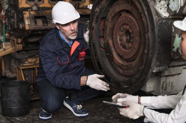 istock Engineer man checking spares machine with engineer team at factory spares train 1441334733