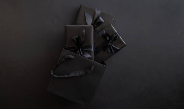 istock Gift box wrapped in black paper with a black bow in a package on a dark background. Holiday concept. Place for text or advertising. Christmas. Black Friday. 1441336436