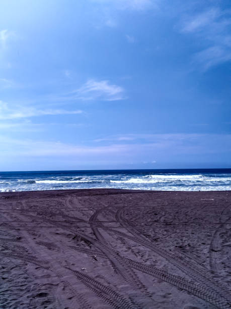 blue sea and black sand