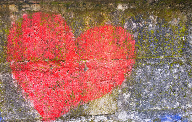 istock Old grungy concrete wall with painted heart as background or texture 1441345049