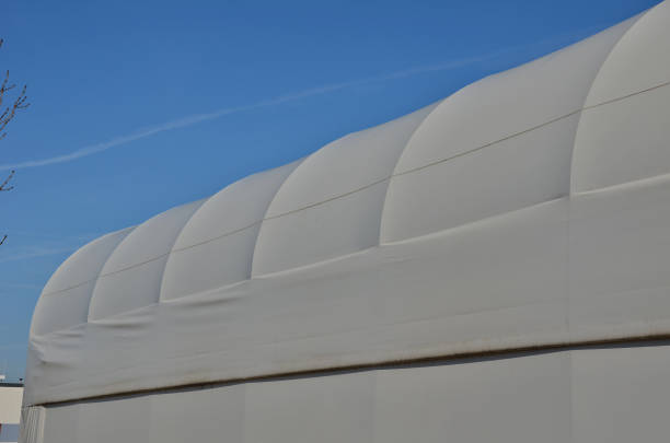 istock container building permanently forms a warehouse with offices. covered with a rubber sheet on tent structure. ventilation with help of a stainless steel propeller chimney. round, hangar, blue sky 1441345147
