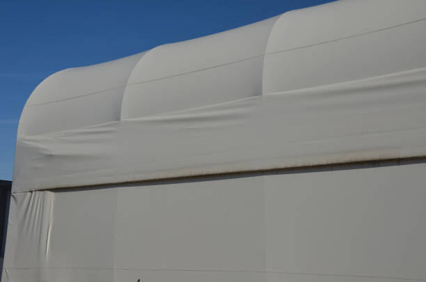 istock container building permanently forms a warehouse with offices. covered with a rubber sheet on tent structure. ventilation with help of a stainless steel propeller chimney. round, hangar, blue sky 1441345183