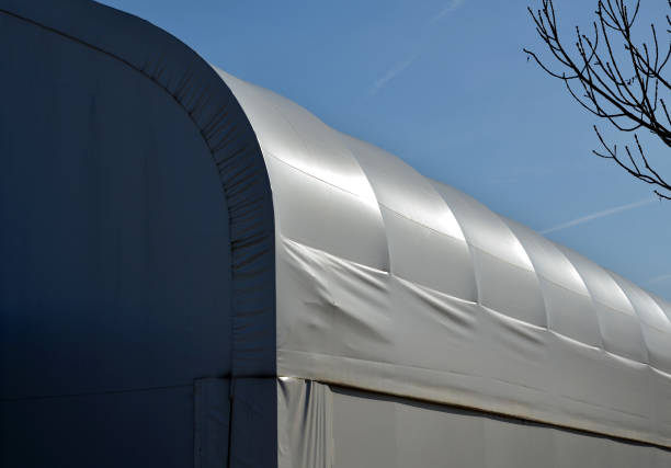container building permanently forms a warehouse with offices. covered with a rubber sheet on tent structure. ventilation with help of a stainless steel propeller chimney. round, hangar, blue sky container building permanently forms a warehouse with offices. covered with a rubber sheet on tent structure. ventilation with help of a stainless steel propeller chimney. round, hangar, blue sky, alternative, ventilation, horse , stretch ceiling, power, quick tramp home stock pictures, royalty-free photos & images
