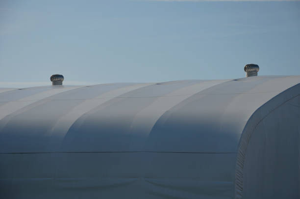 istock container building permanently forms a warehouse with offices. covered with a rubber sheet on tent structure. ventilation with help of a stainless steel propeller chimney. round, hangar, blue sky 1441345501