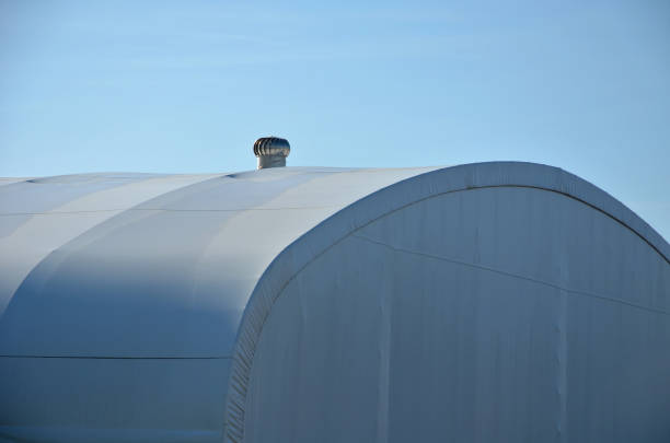istock container building permanently forms a warehouse with offices. covered with a rubber sheet on tent structure. ventilation with help of a stainless steel propeller chimney. round, hangar, blue sky 1441345502