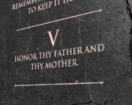 A view of the fifth commandment etched into a cracked stone tablet on an isolated background - 3D render
