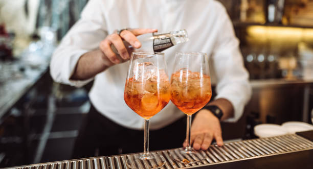 barista che prepara un drink davanti al bancone del bar - cocktail transparent cocktail shaker glass foto e immagini stock