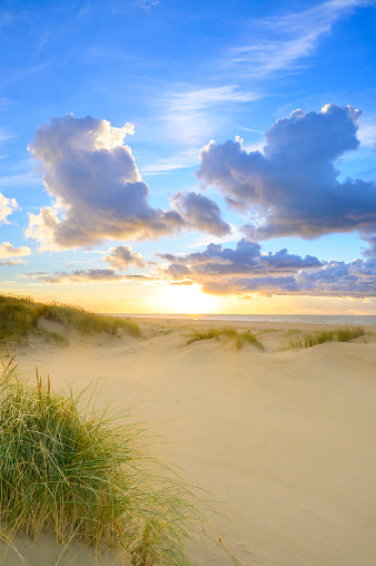 Sunset at the beach of Texel with sand dunes in the foreground during a beautiful fall day at the Wadden island.