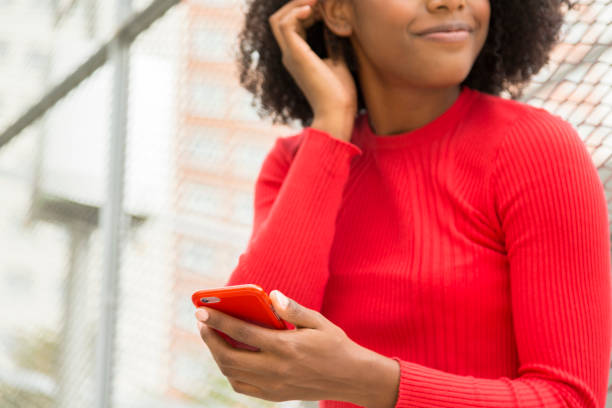 istock cropped unrecognizable young woman with mobile phone in hand looking sideways 1441347104