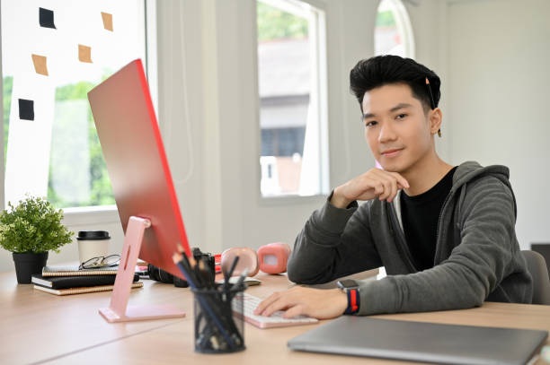istock Handsome Asian male programmer to web developer sitting at his modern office desk 1441350306