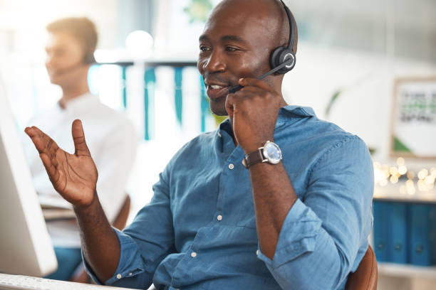 istock Black businessman call center conversation in office, working at help desk online telemarketing company. Customer service support, consultant talking on microphone and career success to contact us 1441351107