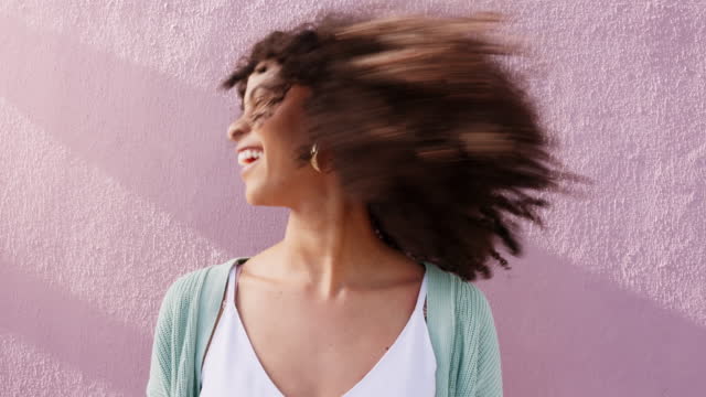 Funky woman shaking natural curly hair on pink wall background, summer sunshine and mockup. Retro, carefree and cool empowerment girl with afro hairstyle for hair care and self love mock up outdoor