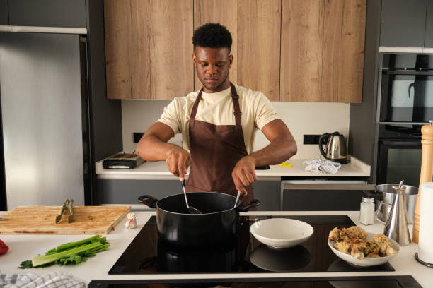 istock Young black man preparing fried chicken mince with vegetables recipe. 1441353294