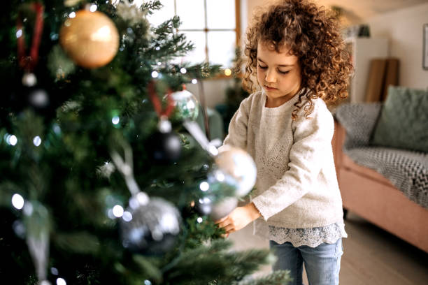 istock Cute little girl decorating christmas tree 1441354946