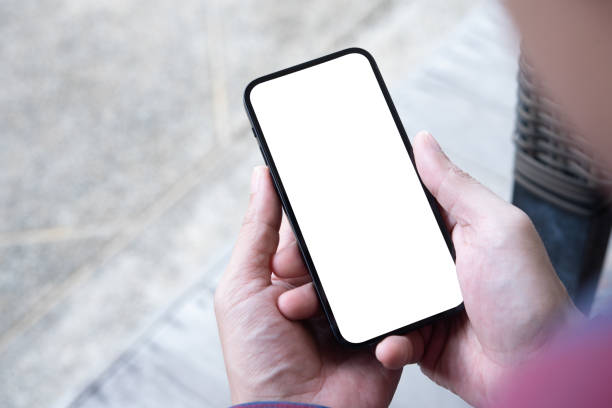 istock Cell phone blank white screen mockup. Man hand holding using mobile phone at coffee shop. empty space template for advertise. People contact business marketing 1441357209
