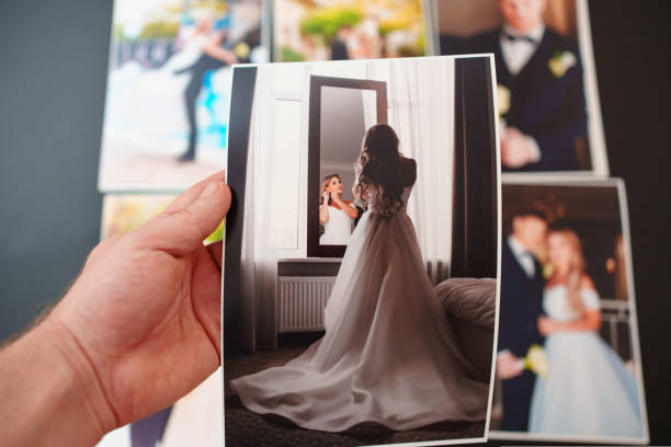 istock printed wedding photos on a black background and in hand. 1441357249