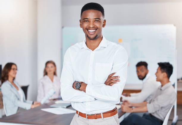 istock African businessman smile, during meeting at work while staff talk at table in office or boardroom. Black man happy as corporate leader, workers have conversation or planning new strategy for company 1441358556