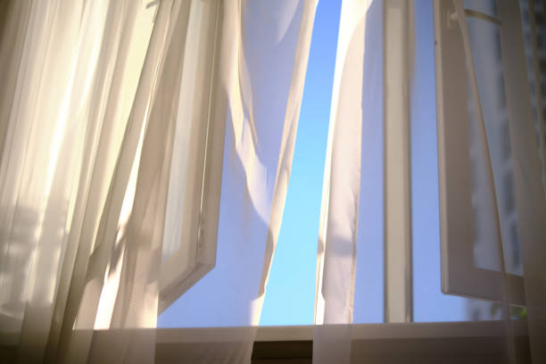 istock wind blows through the open window in the room. white curtain veil from an open window. background for the concept of slow life. fresh air fills the room. 1441358576