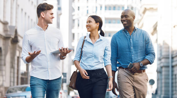istock Startup entrepreneur, friends or corporate workers discuss project while walking in the city. Diversity, happy and business people talking, walk and conversation on commute to work in the morning 1441360543