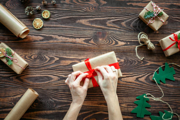 istock Hands tying a red bow on a Christmas gift box 1441362911
