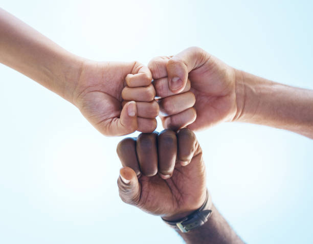 istock Fist bump, teamwork and friends in support, motivation and trust work together for success, partnership and diversity outdoor. Hands of people in collaboration, reunion and connection for unity goal 1441363046