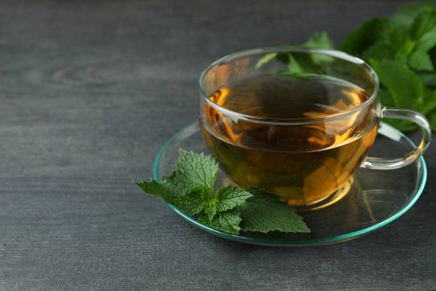 istock Cup of nettle tea on dark wooden table 1441364971