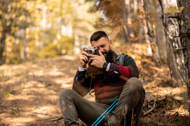 istock Portrait of a hiker sitting on the ground while taking photos 1441365155