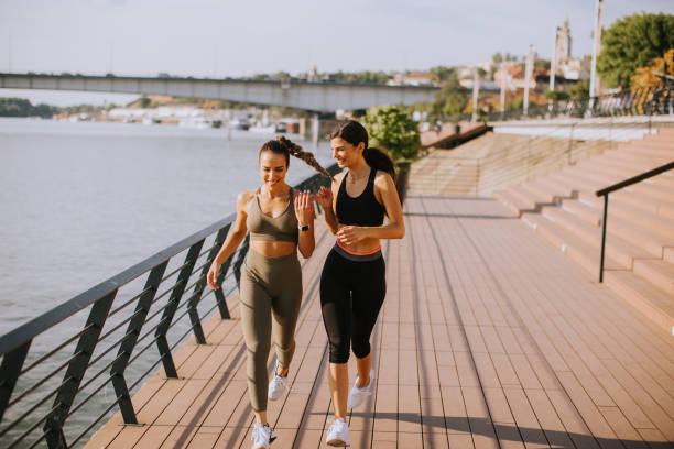 istock Young woman taking running exercise by the river promenade 1441365376
