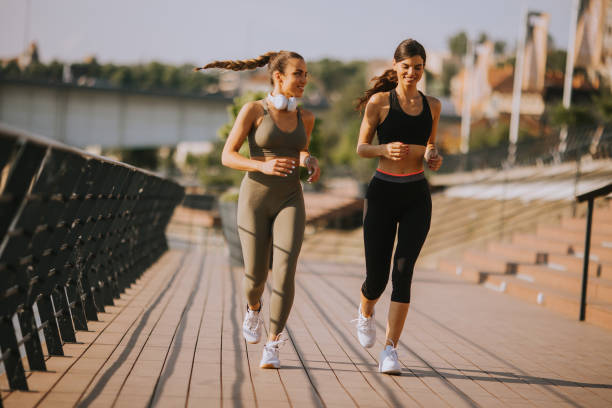 istock Young woman taking running exercise by the river promenade 1441365382