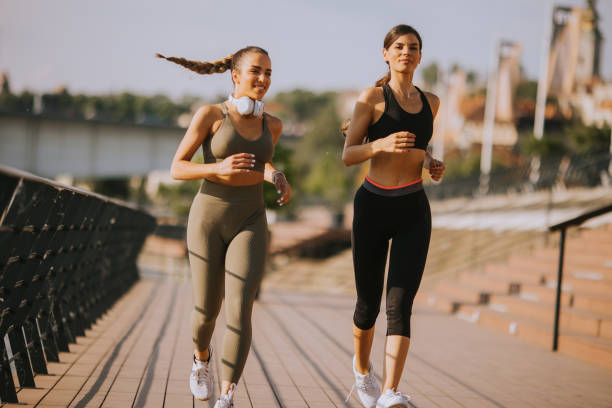 istock Young woman taking running exercise by the river promenade 1441365414