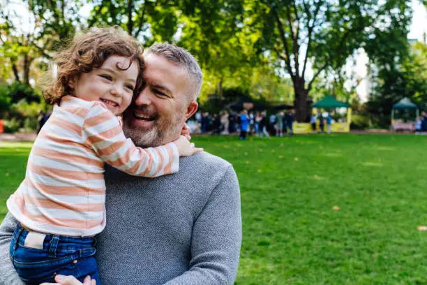 Portrait of young father carrying his daughter.