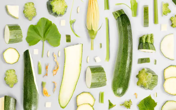 Zucchini vegetable piece, slice and leaf collection. Flat lay, seamless abstract background.