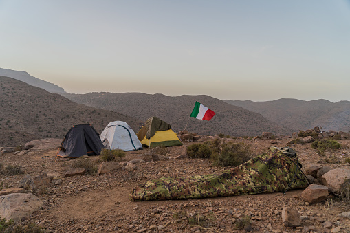 Camp with tents in the Middle Atlas in Morocco at the last light of a November sunset with the mountains in the background.