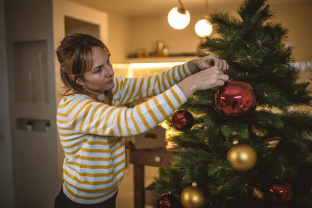 istock Woman decorating Christmas tree for the upcoming holidays 1441367968