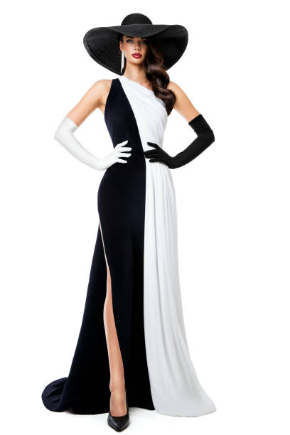 femme robe de soirée noire et blanche. modèle de mode en robe contrastée longue du soir. élégante dame en chapeau noir et gants sur fond isolé. jeu d’échecs queen concept - evening wear photos et images de collection