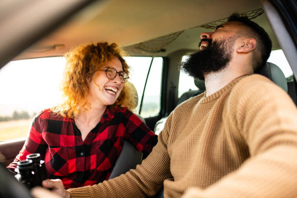 istock Lovely young couple having a laugh while sitting in a car 1441369462