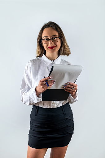 Happy smiling cheerful young business woman with clipboard isolated on white background. business concept. business woman