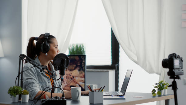 istock Creative internet influencer putting headphones on while recording video blog. 1441371435
