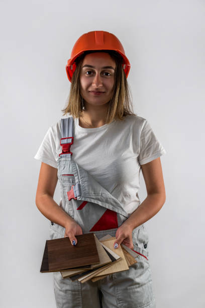 istock beautiful female construction worker holding a folder with documents in her hands and smiling 1441371524