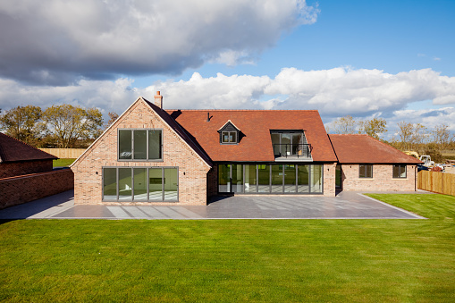 Hardwick, Cambridgeshire, England - October 26 2018: Brand new luxury detached brick built home with landscaped garden and patio with bifold doors