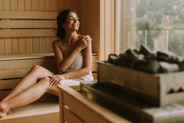 giovane donna che si rilassa nella sauna - trattamento di benessere foto e immagini stock