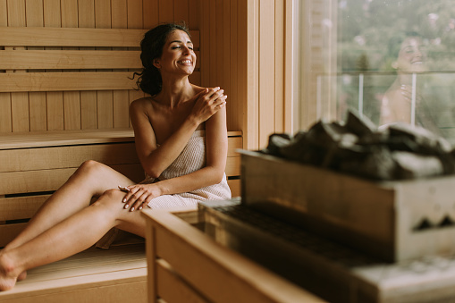 Attractive young woman relaxing in the sauna