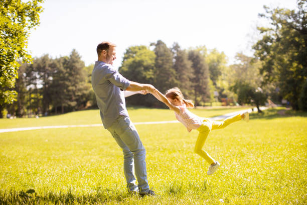 istock Father with daughter having fun on the grass at the park 1441376996