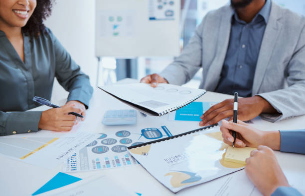 istock Business team, financial report and collaboration meeting while discussing documents for investors to review revenue performance analytics data. Executive men and women with paperwork while planning 1441378701