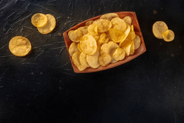 istock Potato chips or crisps, shot from above on a black slate table 1441380758