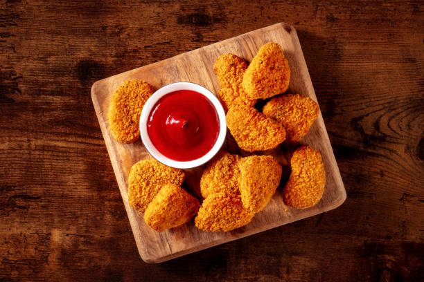 istock Chicken nuggets with ketchup sauce on a rustic wooden background 1441381417