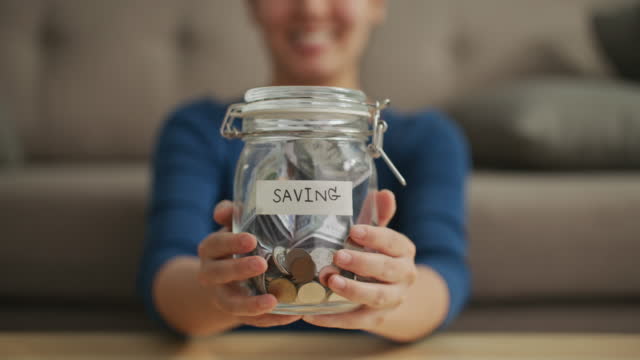 Woman showing Money saving jar