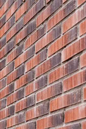 Rough wall of red brown rugged bricks close-up