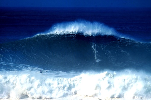 A big wave surfer rides one of Portugal's giant waves at Praia do Norte, Nazare