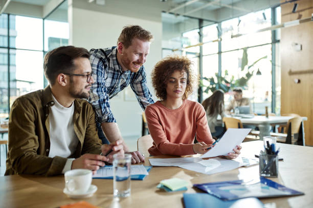 istock Team of creative colleague analyzing documents in a modern office. 1441388591
